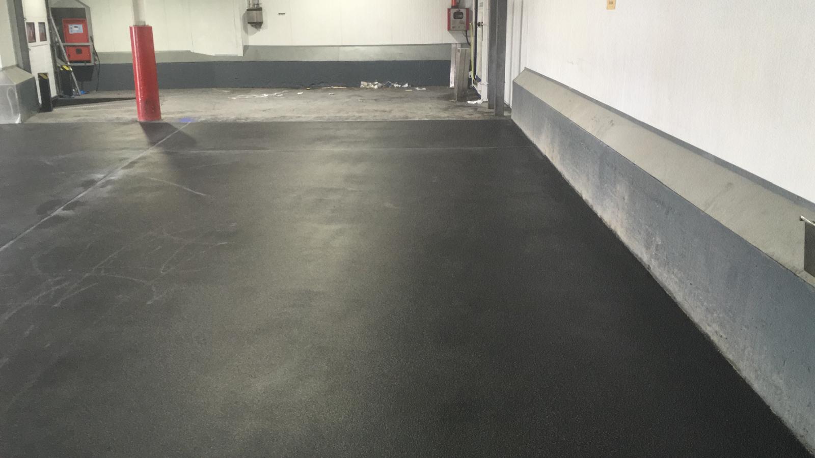Dark grey floor with safety bollards